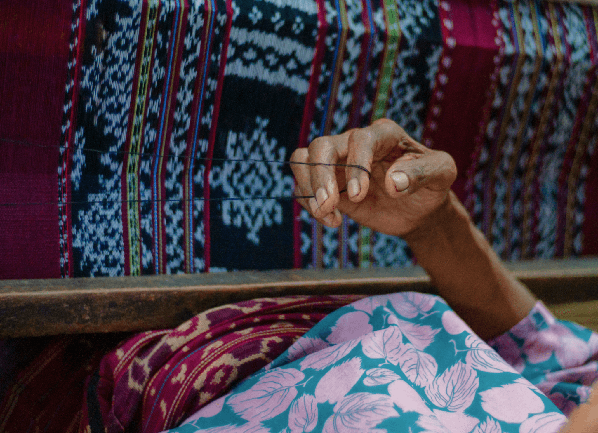 Close up photograph of weaver creating a colourful pattern