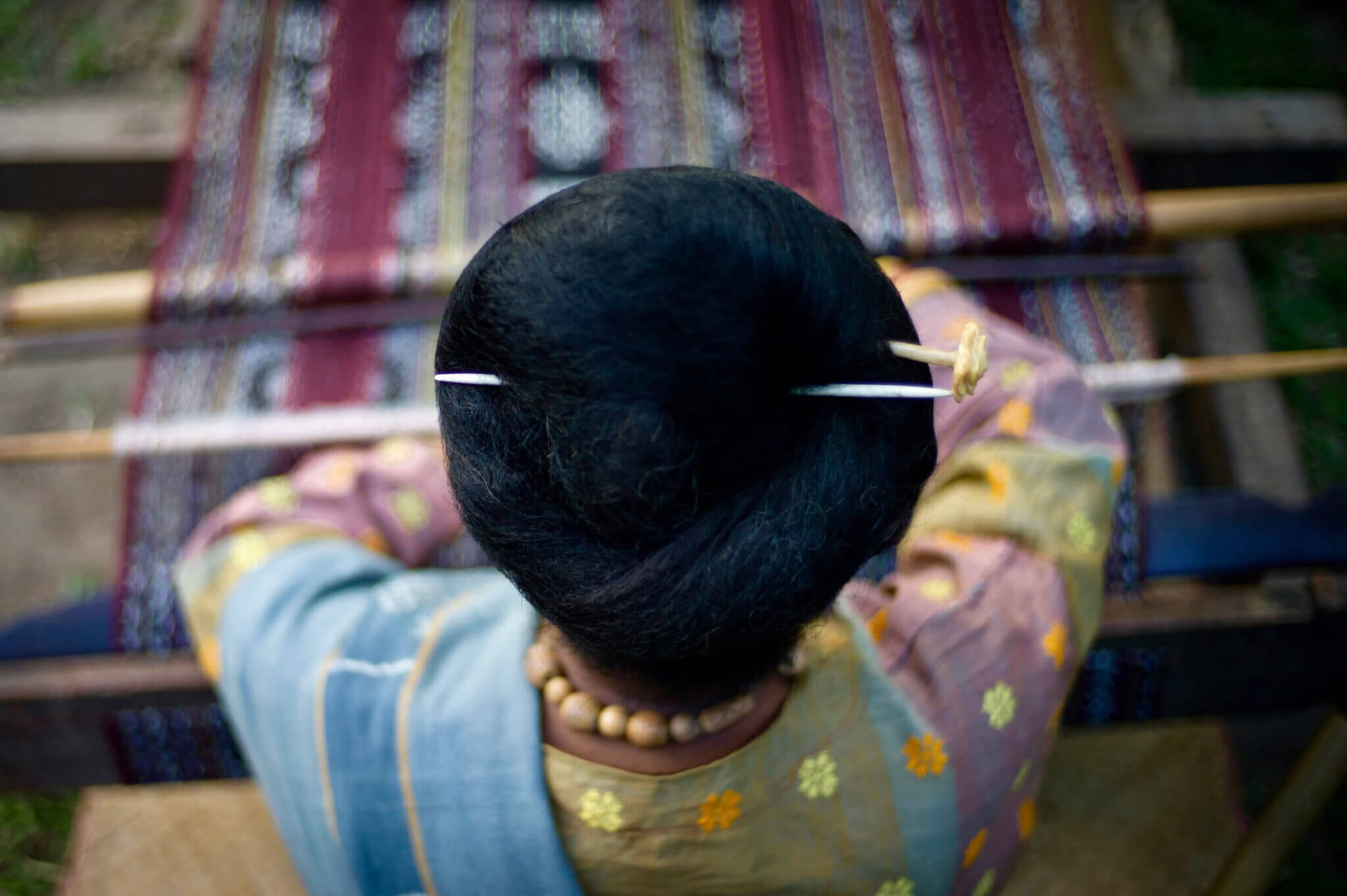 Photo from behind a woman with two pins in her hair